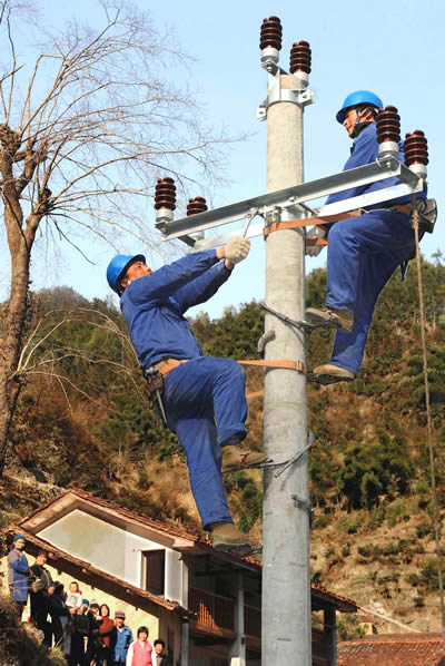 2月28日,电力工人们在浙江省武义县大溪口乡高水村安装电力设施.